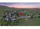 Aerial view of the property in a quiet neighborhood with rolling hills and mountains during a colorful sunset at 87 Deerwood Dr, Littleton, CO 80127