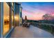 An outdoor wooden deck with a patio table set provides beautiful sunset views and access to the kitchen at 87 Deerwood Dr, Littleton, CO 80127
