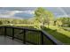 Scenic backyard view from deck with lush greenery, mature trees, distant mountains, and a glimpse of a rainbow at 87 Deerwood Dr, Littleton, CO 80127