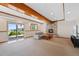 Finished basement featuring a stone fireplace, beamed ceiling, and walk-out access at 87 Deerwood Dr, Littleton, CO 80127