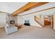 Finished basement featuring a stone fireplace, exposed wood beams, and staircase at 87 Deerwood Dr, Littleton, CO 80127