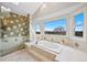 Bright bathroom featuring a glass shower, soaking tub, tile floor and picturesque window views at 87 Deerwood Dr, Littleton, CO 80127