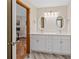 Bright bathroom with a double vanity, twin mirrors, and a door into the bedroom at 87 Deerwood Dr, Littleton, CO 80127