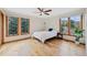 Sun-filled bedroom with hardwood floors, natural wood trim windows, and ceiling fan at 87 Deerwood Dr, Littleton, CO 80127