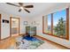 Bedroom room featuring wood floors, large windows with views, ceiling fan and an attached bathroom at 87 Deerwood Dr, Littleton, CO 80127