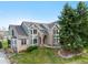 Stunning two-story home featuring brick and siding, complemented by a lush green lawn and mature tree at 87 Deerwood Dr, Littleton, CO 80127