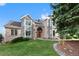 Beautiful two-story brick home with arched entryway and well-maintained landscaping at 87 Deerwood Dr, Littleton, CO 80127