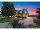 Exterior front view showcasing the home's facade with lush landscaping at twilight at 87 Deerwood Dr, Littleton, CO 80127
