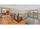 Bright hallway with hardwood floors, wood railing staircase, fireplace and picturesque window views at 87 Deerwood Dr, Littleton, CO 80127