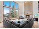 Spacious living room with floor-to-ceiling windows, brick fireplace, and hardwood floors at 87 Deerwood Dr, Littleton, CO 80127