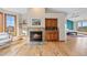 Living room featuring hardwood floors, a fireplace, built-in shelves, and a wet bar at 87 Deerwood Dr, Littleton, CO 80127