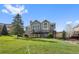 Exterior view of the home's back showcasing a spacious deck and well-manicured lawn at 87 Deerwood Dr, Littleton, CO 80127