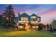 Two-story home with large deck and walk out basement with a landscaped yard at sunset at 87 Deerwood Dr, Littleton, CO 80127