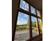 Expansive windows showcase views of the deck, green hills, and lush greenery, flooding the home with natural light at 87 Deerwood Dr, Littleton, CO 80127