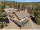 Aerial view of the house showing the structure and the surrounding woods and mountain views at 11648 Broken Arrow Dr, Conifer, CO 80433