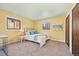 Bright bedroom features carpet flooring, yellow walls, and two windows at 11648 Broken Arrow Dr, Conifer, CO 80433