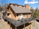 Attractive exterior view of raised brown home featuring wraparound deck with seating and mountain views at 11648 Broken Arrow Dr, Conifer, CO 80433
