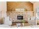 Close-up of stone fireplace with wooden mantle and seating area at 11648 Broken Arrow Dr, Conifer, CO 80433