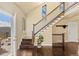 Bright foyer with wood floors, staircase, mountain views, and access to deck at 11648 Broken Arrow Dr, Conifer, CO 80433