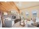 Comfortable living room featuring a stone fireplace, natural light, and cozy seating at 11648 Broken Arrow Dr, Conifer, CO 80433