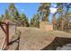 Backyard shed behind fence surrounded by a lawn and mature trees at 11648 Broken Arrow Dr, Conifer, CO 80433