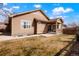 Tan home showcasing the backyard and covered patio with a well-maintained lawn at 5172 Purple Mustard Ct, Brighton, CO 80601