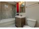 Bathroom features a shower and tub combination, gray tile surround, a skylight, and wood vanity at 1601 S Glencoe St, Denver, CO 80222