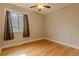 Cozy bedroom with hardwood floors, neutral walls, a ceiling fan, and natural light from a window at 1601 S Glencoe St, Denver, CO 80222