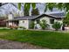 Charming single-story home featuring a well-manicured lawn, brick facade, and lovely flowerbeds at 1601 S Glencoe St, Denver, CO 80222
