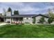 Attractive gray brick home with a green lawn and colorful flower planters under the front windows at 1601 S Glencoe St, Denver, CO 80222