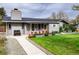 Charming home with colorful flower boxes, an inviting walkway and lush green lawn at 1601 S Glencoe St, Denver, CO 80222