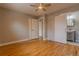 Comfortable main bedroom with hardwood floors, ceiling fan, closet, and a barn door to the bathroom at 1601 S Glencoe St, Denver, CO 80222