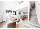 Bright living room with modern furniture, light wood floors, and access to the kitchen and staircase at 1555 W 43Rd Ave, Denver, CO 80211