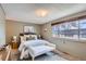 Cozy bedroom with a comfortable bed, soft rug, and a large window providing natural light at 431 S Balsam St, Lakewood, CO 80226