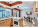 Functional kitchen featuring wooden cabinets, eat-in dining area, and modern fixtures at 431 S Balsam St, Lakewood, CO 80226