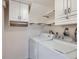 Functional laundry room with appliances, storage cabinets, and efficient layout at 431 S Balsam St, Lakewood, CO 80226