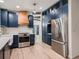Modern kitchen with blue cabinets, stainless steel appliances, and wood accents at 8916 Sunridge Hollow Rd, Parker, CO 80134