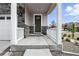 Inviting front porch with stone accents, white railing, and a decorative wreath on the front door at 27504 E 1St Pl, Aurora, CO 80018