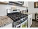 Close-up of a stainless steel range with granite countertops and white subway tile backsplash at 27504 E 1St Pl, Aurora, CO 80018