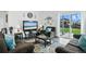 Comfortable living room featuring a plush sofa, armchair, and a sliding glass door that offers backyard views at 27504 E 1St Pl, Aurora, CO 80018