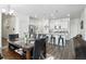 Open-concept living space with modern furnishings, dining area, and an adjacent kitchen with white cabinets at 27504 E 1St Pl, Aurora, CO 80018