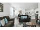 Open-concept living space with modern furnishings, dining area, and an adjacent kitchen with white cabinets at 27504 E 1St Pl, Aurora, CO 80018