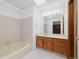 Bathroom featuring a bathtub with a shower, a single vanity, a well-lit mirror, and modern fixtures at 1770 S Quintero Way, Aurora, CO 80017