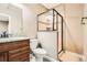 Tiled bathroom features a granite countertop vanity and glass enclosed shower with mosaic tile accent and neutral color palette at 736 Trenton St, Denver, CO 80230