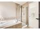Bathroom with a glass shower and a soaking tub with decorative tile at 736 Trenton St, Denver, CO 80230