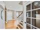 Foyer view with hardwood floors, white-painted stairs and a door with glass panes at 736 Trenton St, Denver, CO 80230