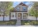 Charming two-story home boasts a welcoming front porch and beautifully maintained landscaping at 736 Trenton St, Denver, CO 80230