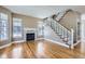 Sunlit living room features gleaming hardwood floors, a classic fireplace and staircase with natural light from large windows at 736 Trenton St, Denver, CO 80230