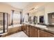 Primary bathroom featuring double sinks, a bathtub, walk-in shower and plenty of storage at 6302 E 135Th Ave, Thornton, CO 80602