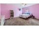 Cozy pink bedroom featuring a large bed, bookcase, and television perfect for relaxation at 6302 E 135Th Ave, Thornton, CO 80602